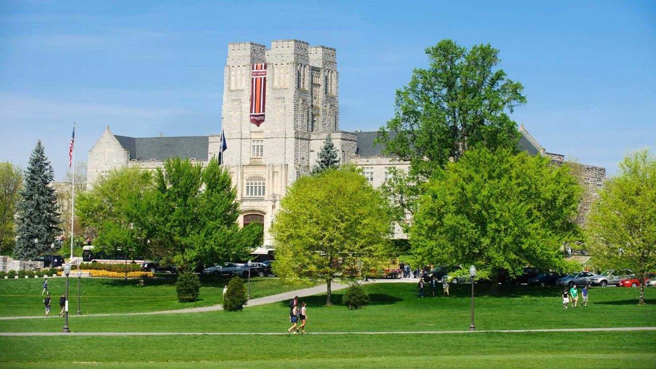 Burruss Hall overlooking the green Drillfield at Virginia Tech under a blue sky